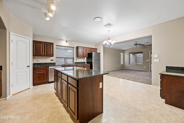 kitchen featuring appliances with stainless steel finishes, decorative light fixtures, sink, a center island, and dark brown cabinets