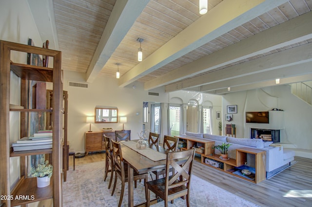 dining area with wooden ceiling, beam ceiling, and light wood-type flooring