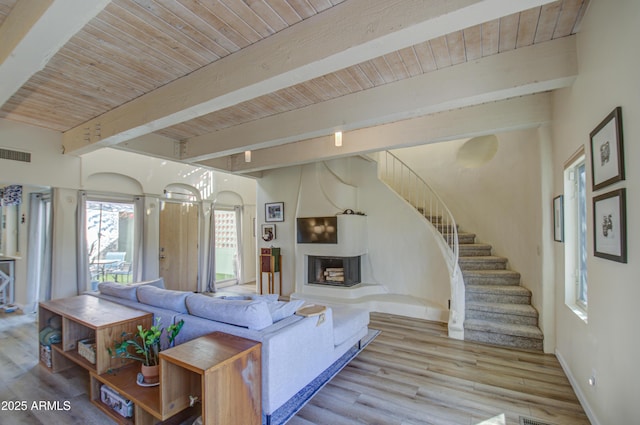 living room with beam ceiling, wood ceiling, and light hardwood / wood-style flooring