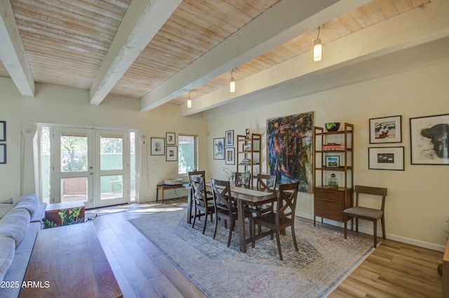 dining space featuring light wood-type flooring, wood ceiling, french doors, and beamed ceiling