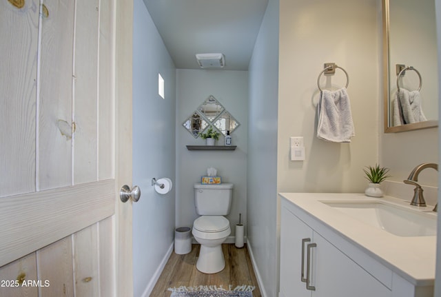 bathroom with toilet, hardwood / wood-style flooring, and vanity