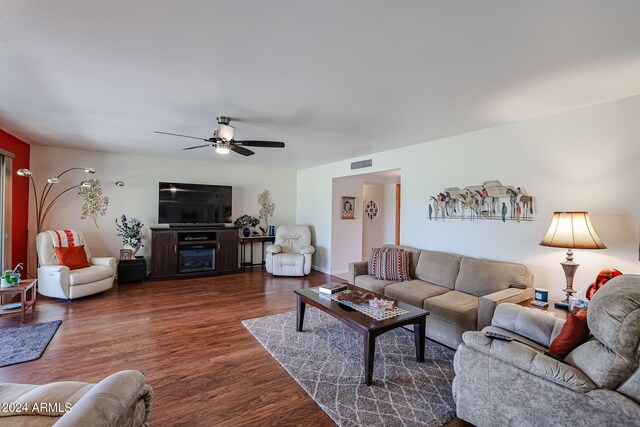 living room featuring ceiling fan and dark wood-type flooring