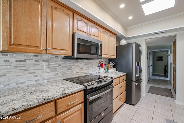 kitchen featuring light stone counters, light tile patterned floors, stainless steel appliances, crown molding, and decorative backsplash