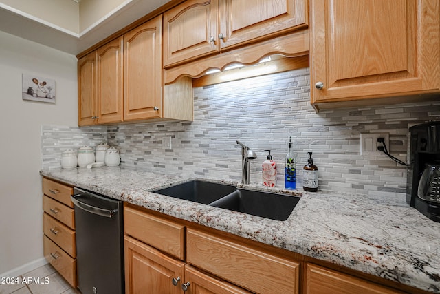 kitchen featuring light tile patterned flooring, sink, dishwasher, light stone countertops, and decorative backsplash