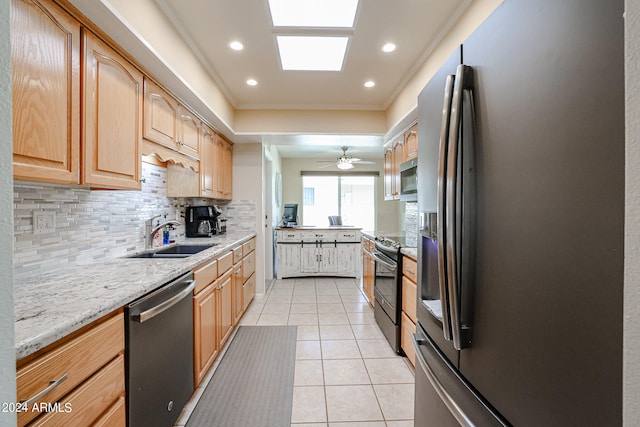 kitchen with light tile patterned flooring, sink, backsplash, appliances with stainless steel finishes, and light stone countertops