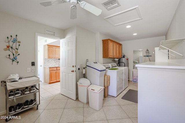 washroom with ceiling fan, light tile patterned floors, cabinets, separate washer and dryer, and water heater