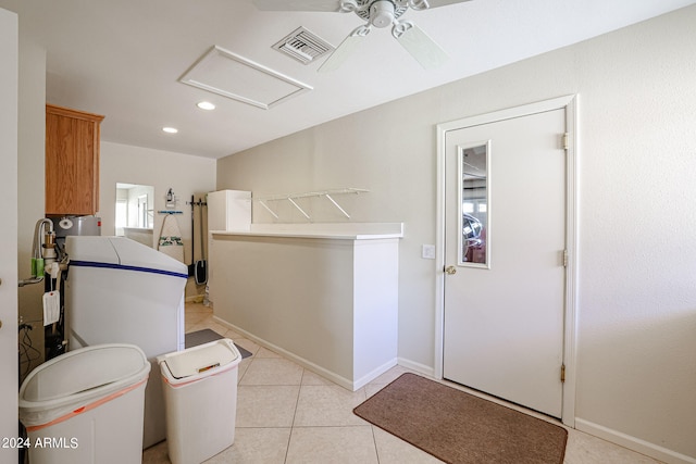 clothes washing area with ceiling fan and light tile patterned floors