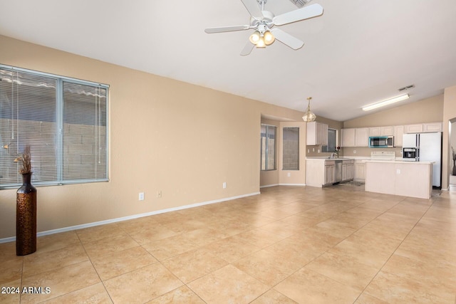 unfurnished living room with ceiling fan, lofted ceiling, sink, and light tile patterned floors