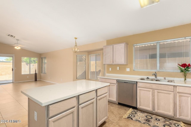 kitchen featuring light brown cabinetry, decorative light fixtures, stainless steel dishwasher, and sink