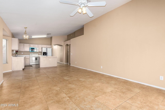 interior space with sink, ceiling fan with notable chandelier, and vaulted ceiling