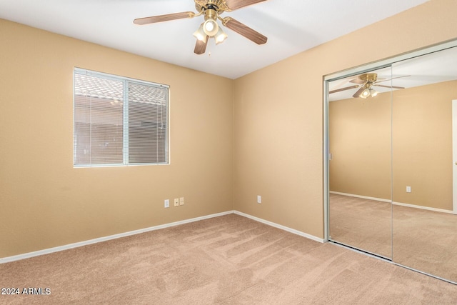 unfurnished bedroom with ceiling fan, a closet, and light colored carpet