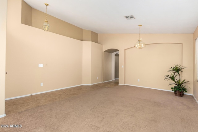 carpeted spare room with high vaulted ceiling