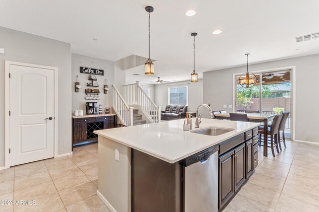 kitchen with stainless steel dishwasher, sink, dark brown cabinets, and a kitchen island with sink