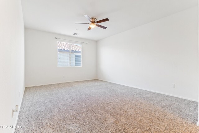 spare room with ceiling fan and light carpet