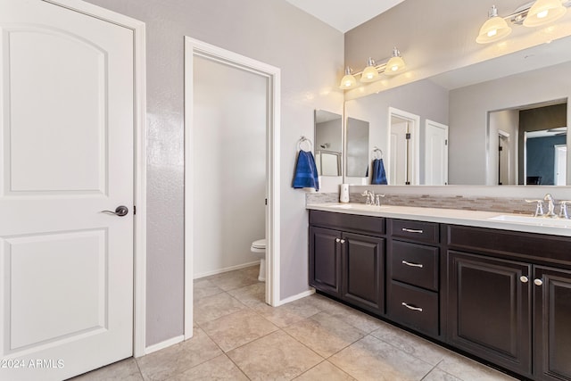 bathroom featuring tile patterned flooring, toilet, and vanity