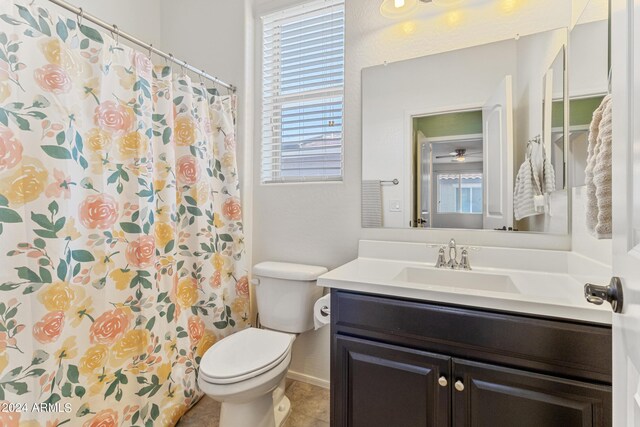 bathroom with walk in shower, toilet, a wealth of natural light, and vanity