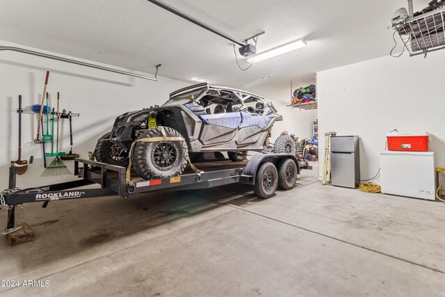 garage featuring a garage door opener, stainless steel fridge, and refrigerator