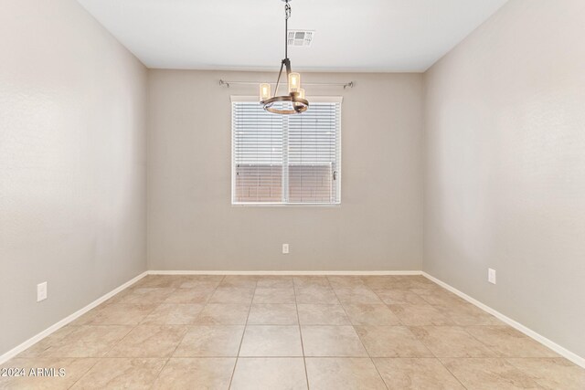 spare room featuring a notable chandelier