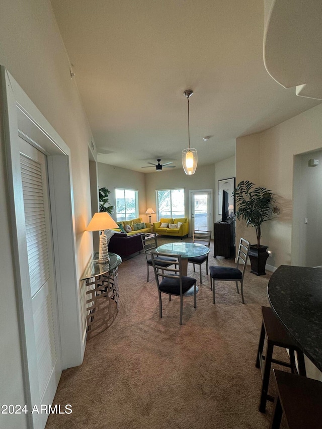 carpeted dining area featuring ceiling fan