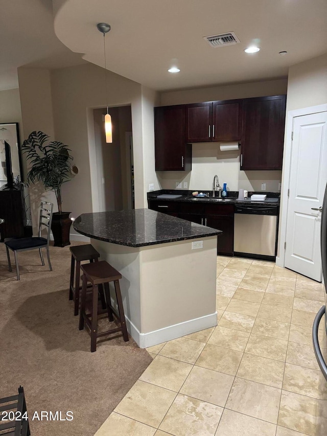 kitchen with sink, dark stone countertops, dishwasher, a kitchen island, and hanging light fixtures