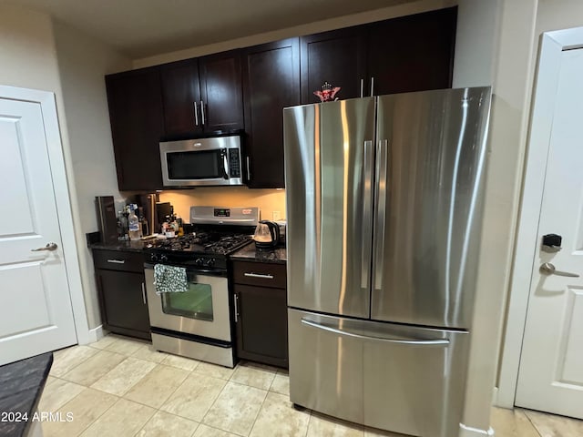 kitchen with light tile patterned flooring, dark stone countertops, dark brown cabinetry, and stainless steel appliances