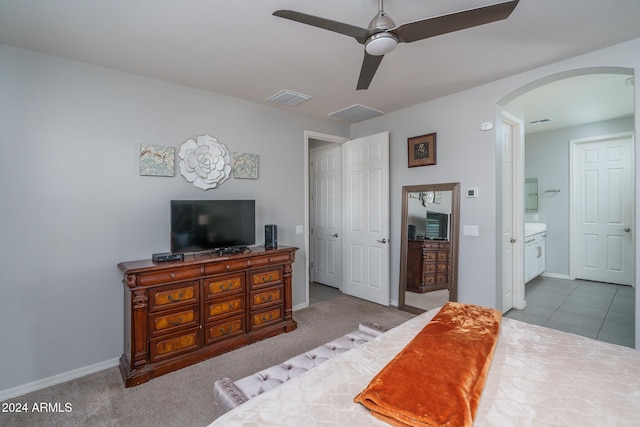 carpeted bedroom featuring connected bathroom and ceiling fan