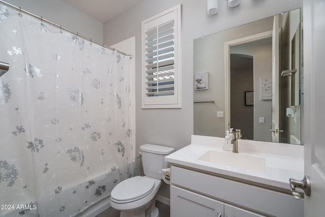 full bathroom featuring shower / bath combo with shower curtain, vanity, and toilet