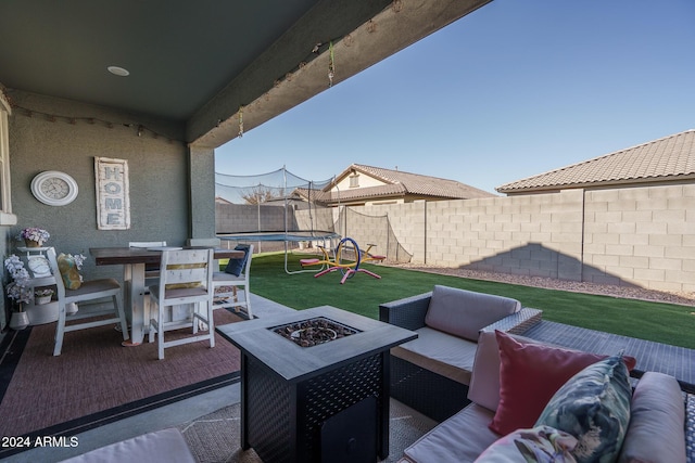 view of patio with an outdoor living space with a fire pit and a trampoline