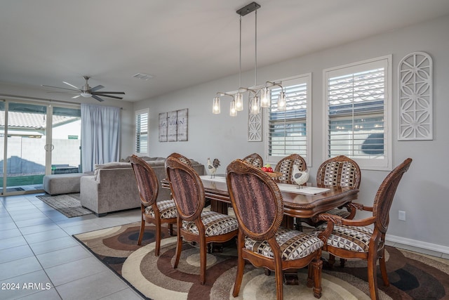 tiled dining area with ceiling fan with notable chandelier