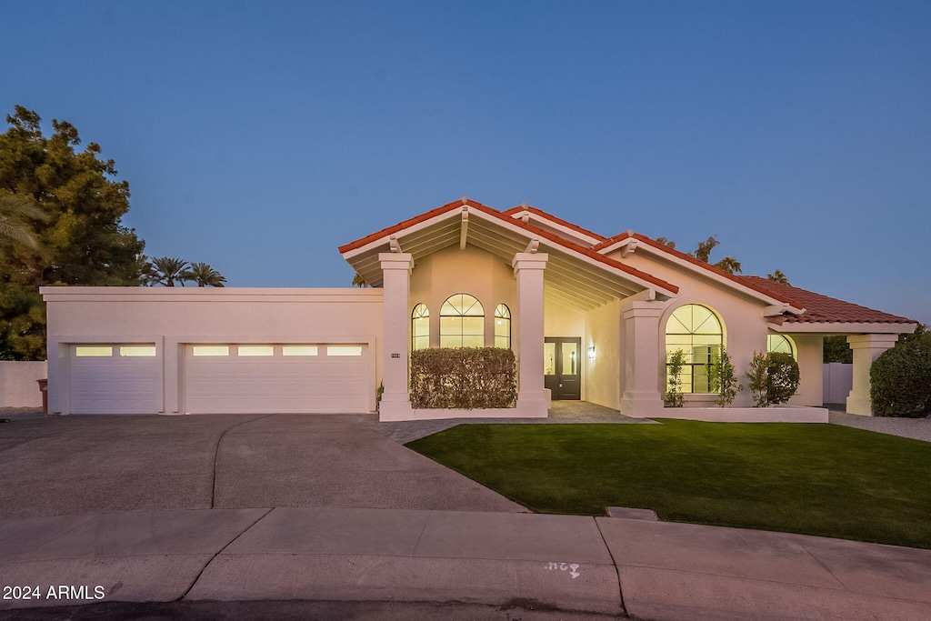 mediterranean / spanish house featuring a yard, french doors, and a garage