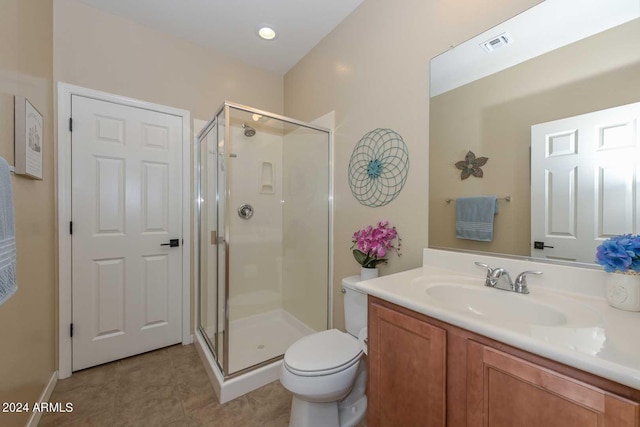 bathroom featuring vanity, a shower with shower door, toilet, and tile patterned flooring