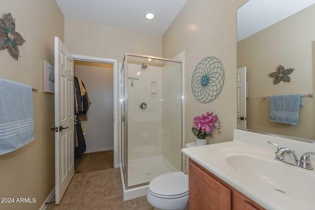 bathroom featuring tile patterned floors, an enclosed shower, vanity, and toilet