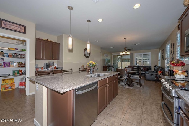 kitchen with ceiling fan, dark brown cabinetry, sink, a center island with sink, and stainless steel appliances