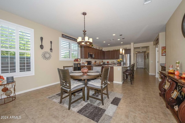 tiled dining space with a notable chandelier