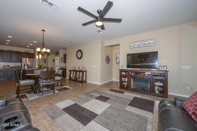 living room with ceiling fan with notable chandelier