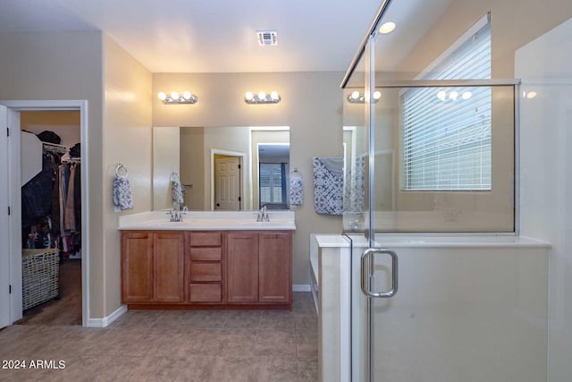 bathroom with walk in shower, vanity, and tile patterned floors