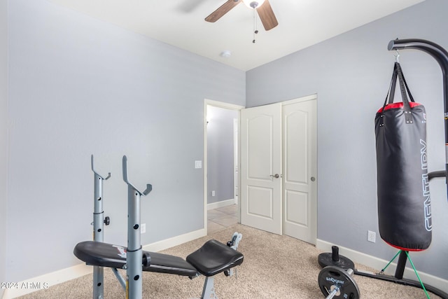 workout area featuring baseboards, light colored carpet, and a ceiling fan