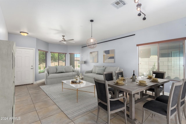 living room with light tile patterned flooring, visible vents, baseboards, and ceiling fan