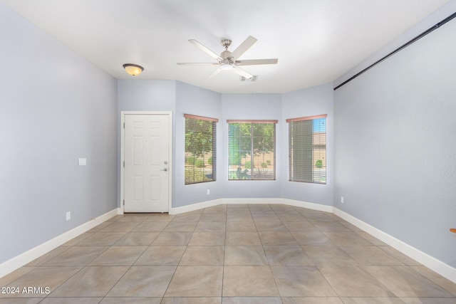 unfurnished room with light tile patterned flooring, a ceiling fan, visible vents, and baseboards