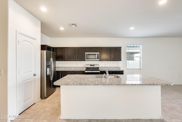 kitchen with light stone counters, visible vents, stainless steel appliances, and a sink