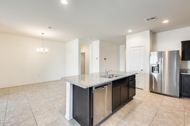 kitchen featuring stainless steel appliances, visible vents, a sink, and light stone counters