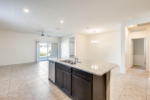 kitchen with light tile patterned flooring, a kitchen island with sink, a sink, dishwasher, and ceiling fan with notable chandelier