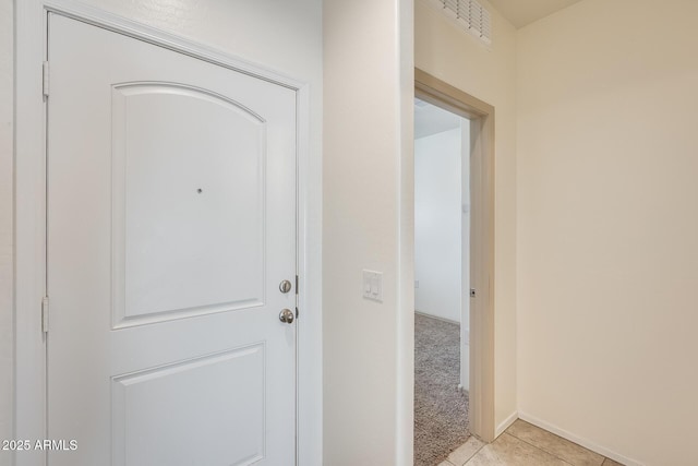 interior space featuring light tile patterned floors, visible vents, and light colored carpet