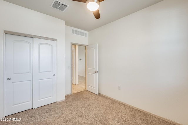 unfurnished bedroom featuring ceiling fan, a closet, carpet flooring, and visible vents