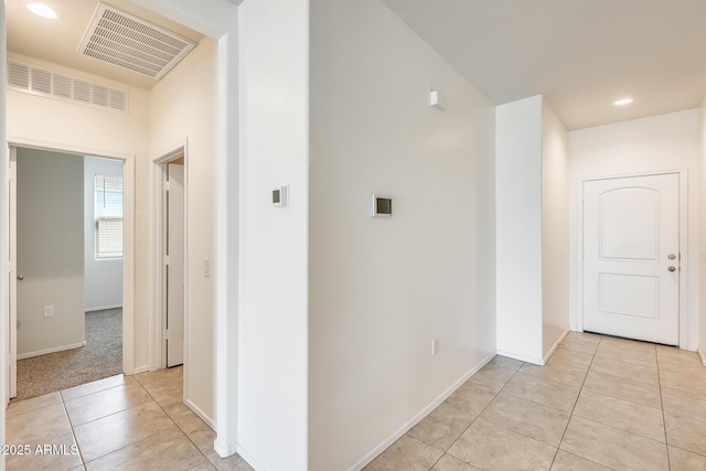 hall with light tile patterned floors, baseboards, visible vents, and recessed lighting