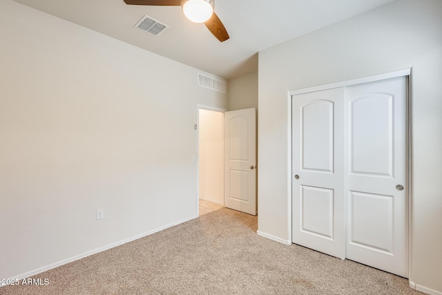 unfurnished bedroom with baseboards, a closet, visible vents, and light colored carpet