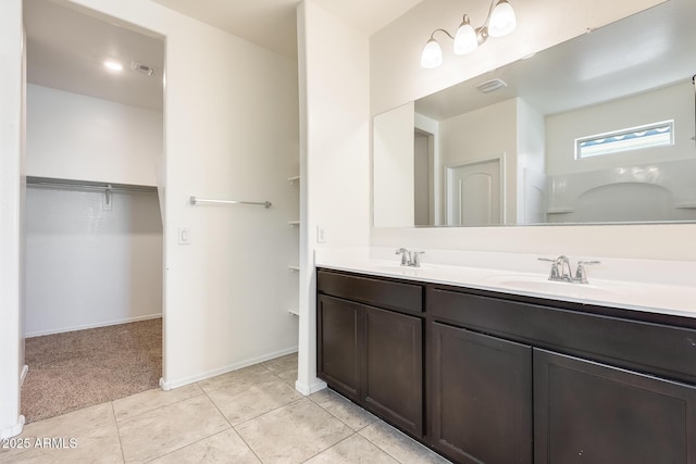 full bath featuring double vanity, visible vents, tile patterned floors, a spacious closet, and a sink