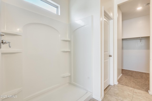 bathroom with a walk in shower, visible vents, and tile patterned floors