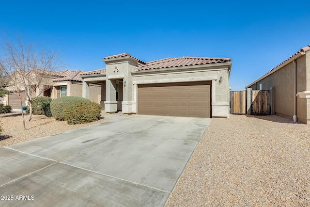 mediterranean / spanish home with concrete driveway, a tiled roof, an attached garage, and stucco siding