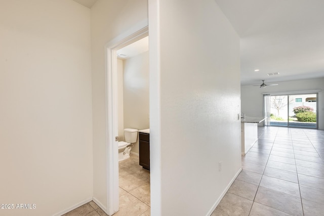 corridor with light tile patterned floors and baseboards